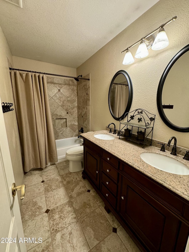 full bathroom with vanity, shower / tub combo, a textured ceiling, and toilet