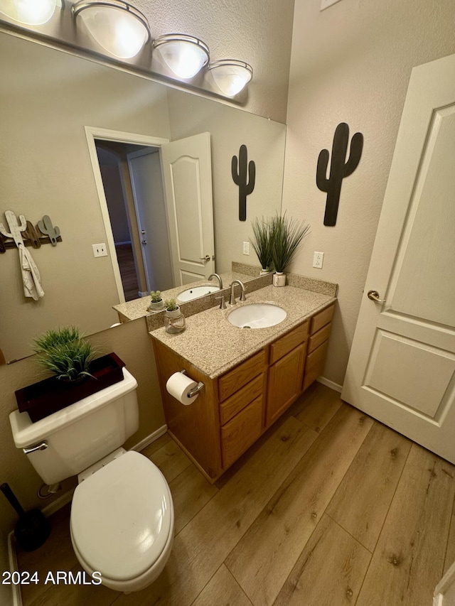 bathroom featuring hardwood / wood-style floors, vanity, and toilet