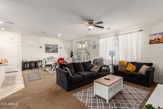 carpeted living room with ceiling fan