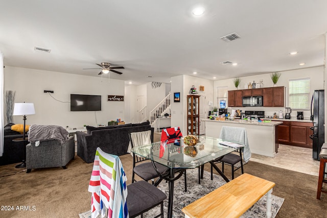 carpeted dining space featuring ceiling fan