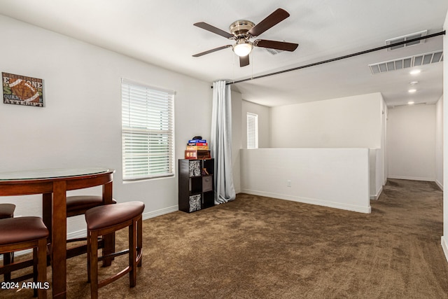 carpeted dining area with ceiling fan