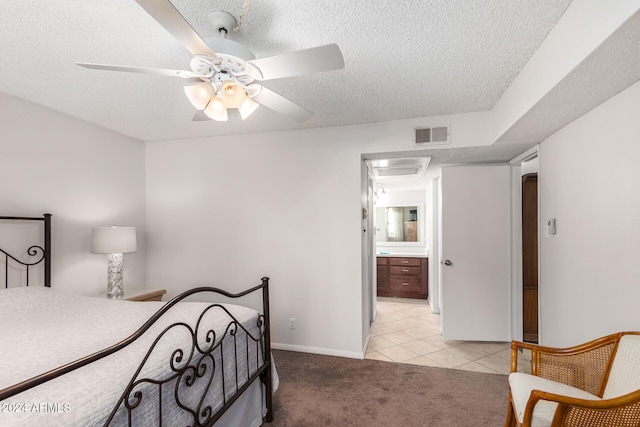 carpeted bedroom featuring ceiling fan, a textured ceiling, and ensuite bath