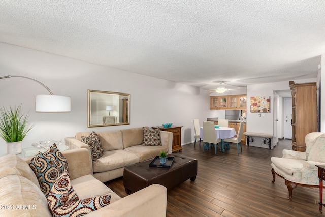 living room featuring ceiling fan, dark hardwood / wood-style flooring, and a textured ceiling