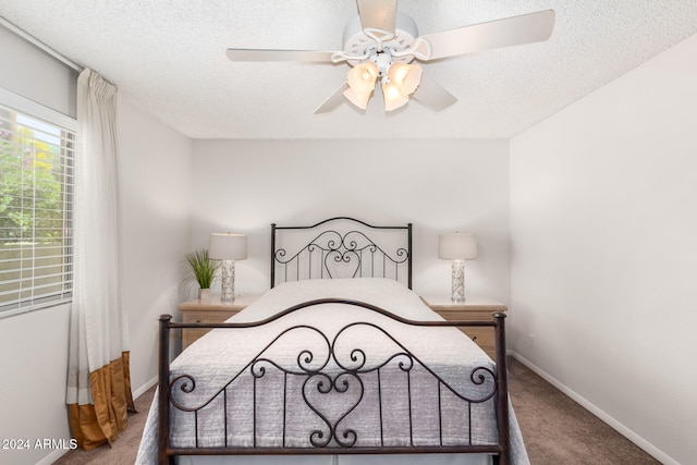 bedroom featuring carpet flooring, ceiling fan, and a textured ceiling