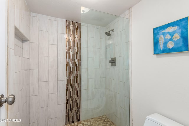 bathroom featuring a tile shower, a textured ceiling, and toilet