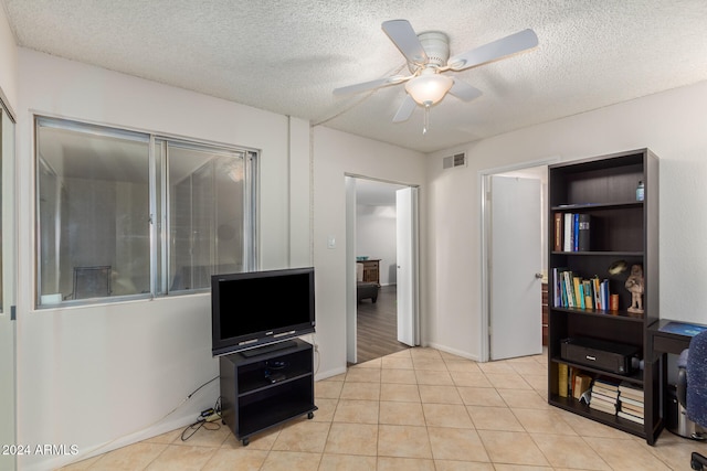 interior space featuring ceiling fan and a textured ceiling