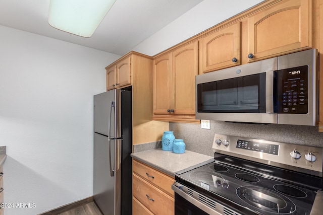 kitchen with light brown cabinets, stainless steel appliances, and dark wood-type flooring