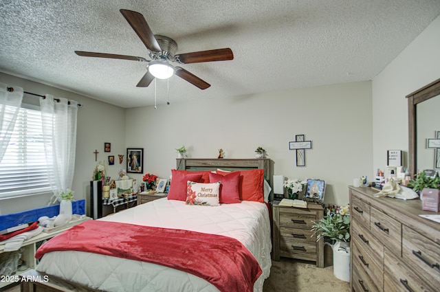 bedroom with ceiling fan, carpet floors, and a textured ceiling