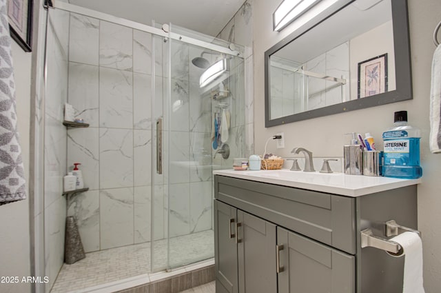 bathroom featuring a shower with door and vanity