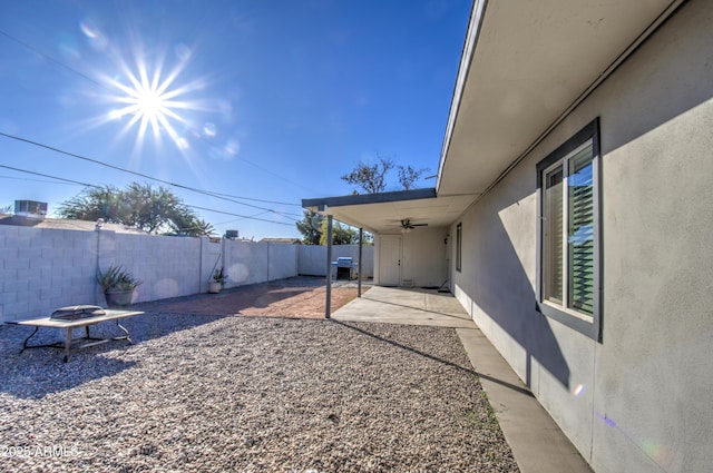 view of yard featuring ceiling fan, a patio, and an outdoor fire pit