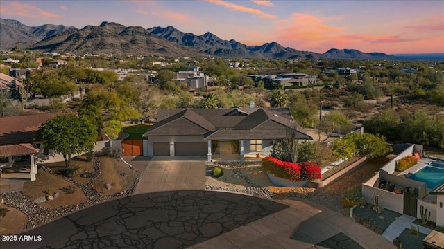 aerial view at dusk featuring a mountain view