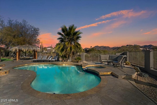 pool at dusk with an in ground hot tub, a mountain view, a gazebo, and a patio