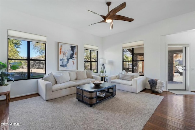 living room featuring dark wood-type flooring and ceiling fan