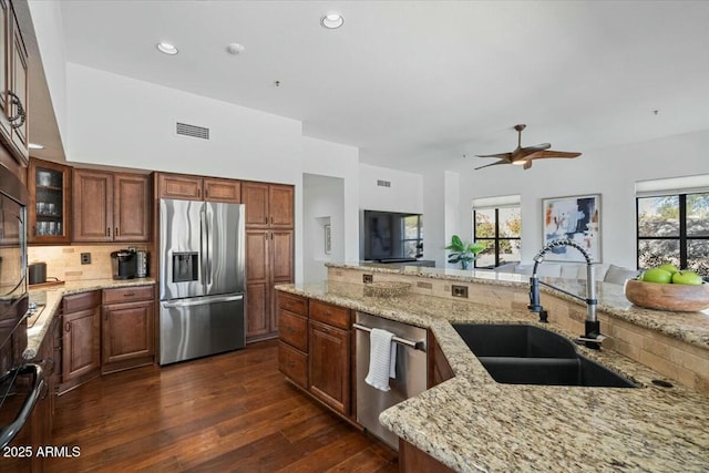 kitchen featuring sink, plenty of natural light, stainless steel appliances, and light stone countertops