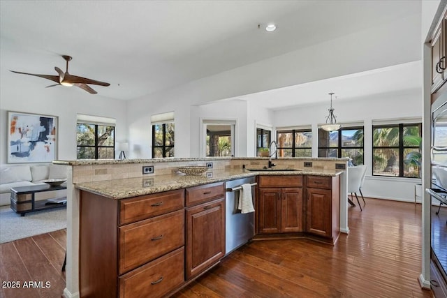 kitchen with dark hardwood / wood-style flooring, hanging light fixtures, sink, and dishwasher