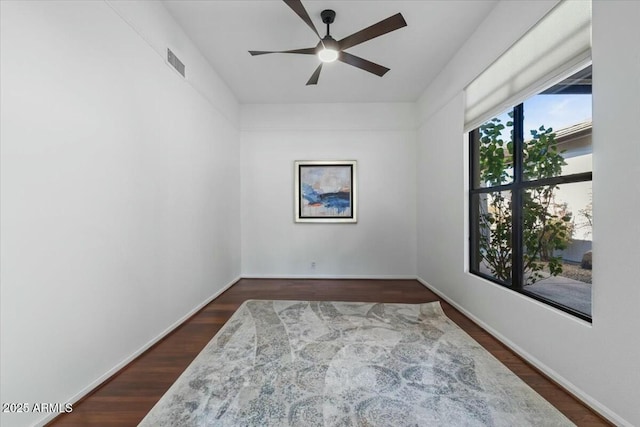 empty room with dark wood-type flooring and ceiling fan