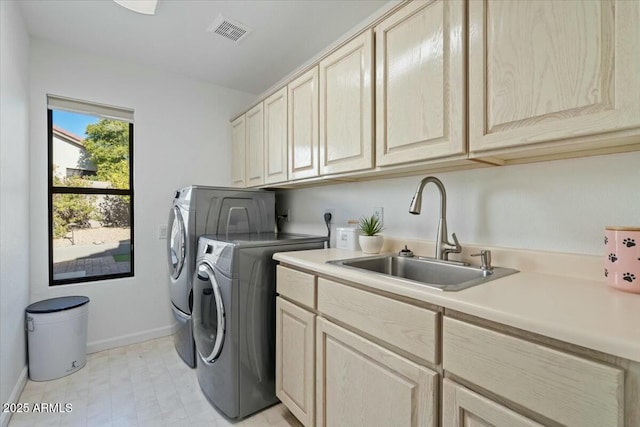 washroom featuring cabinets, sink, and independent washer and dryer