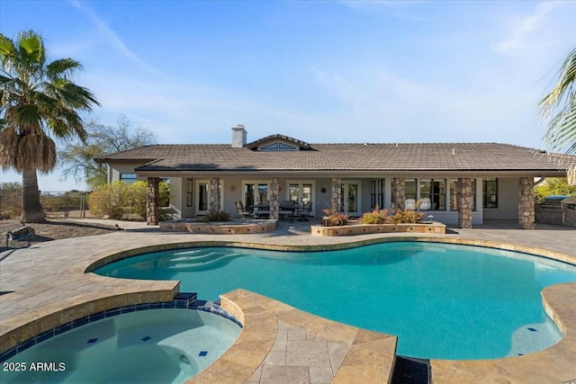 view of swimming pool featuring an in ground hot tub and a patio area