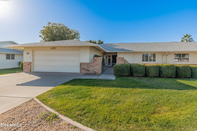 ranch-style home featuring a garage and a front lawn