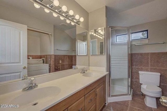 bathroom featuring washer / dryer, tile patterned floors, vanity, tile walls, and toilet