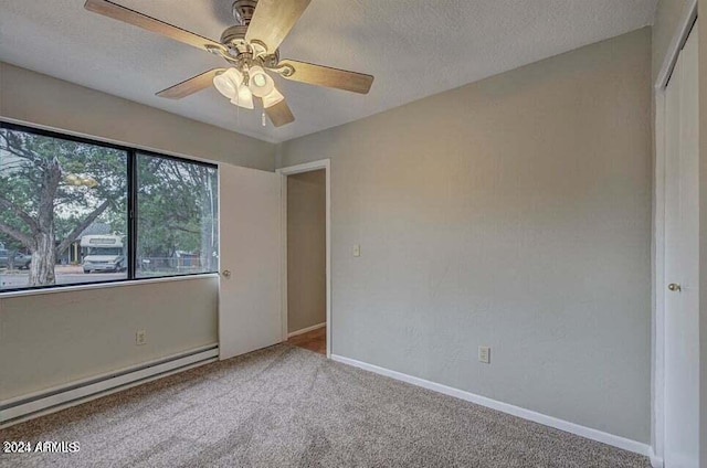 empty room featuring a textured ceiling, ceiling fan, carpet floors, and a baseboard radiator