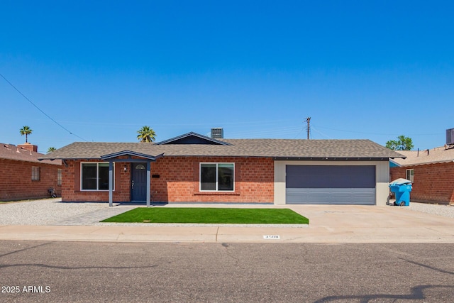 ranch-style house with roof with shingles, brick siding, driveway, and an attached garage