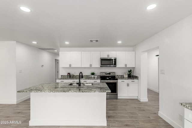 kitchen with a sink, visible vents, baseboards, and appliances with stainless steel finishes