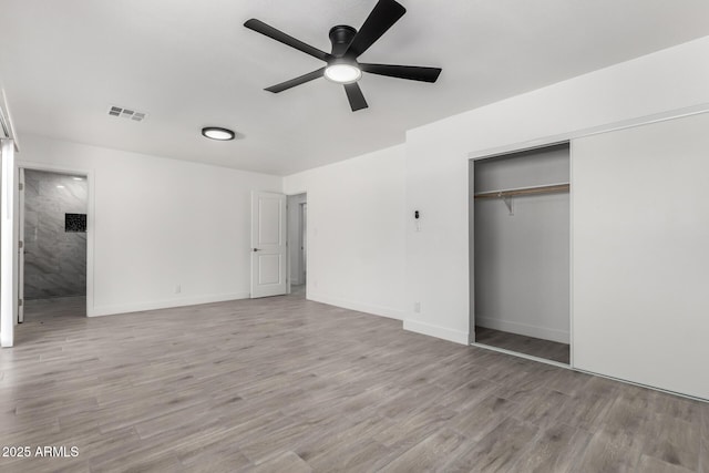 unfurnished bedroom featuring a closet, light wood finished floors, baseboards, and visible vents