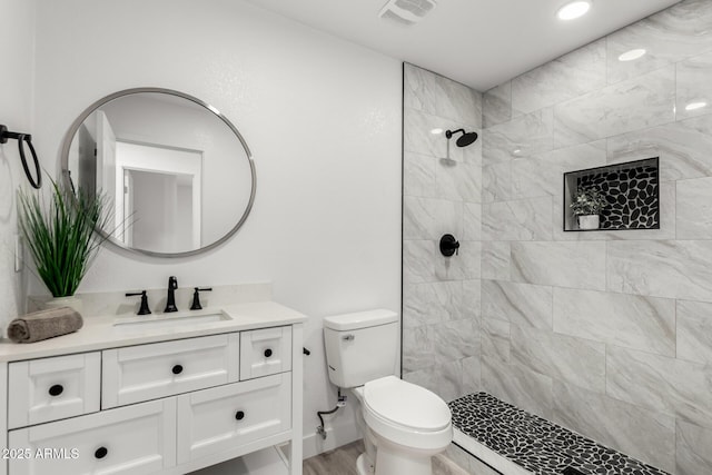 bathroom with visible vents, a tile shower, toilet, recessed lighting, and vanity