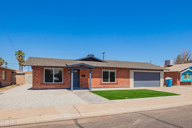 single story home featuring a front lawn, brick siding, an attached garage, a shingled roof, and driveway