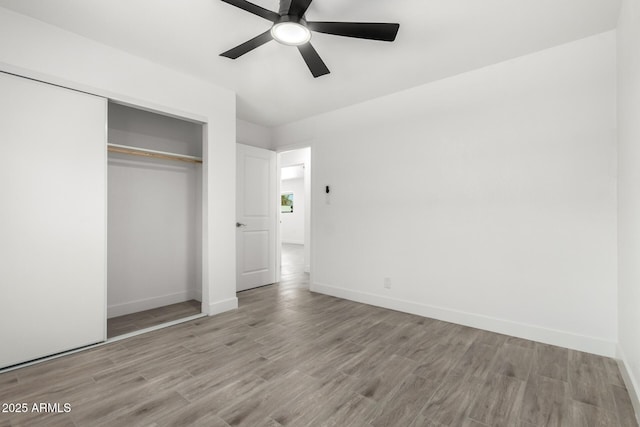unfurnished bedroom featuring a closet, baseboards, and wood finished floors