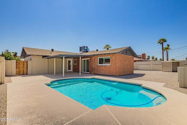 view of swimming pool featuring a patio, a fenced backyard, a fenced in pool, and a gate