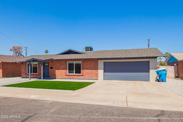 ranch-style home with a front yard, an attached garage, concrete driveway, brick siding, and roof with shingles