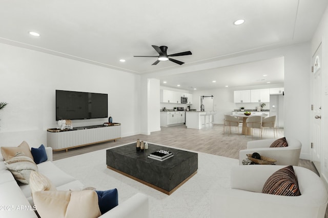 living room featuring baseboards, recessed lighting, light wood-style floors, and ceiling fan