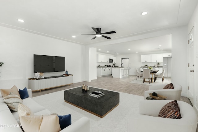 living area featuring recessed lighting, light wood-style flooring, baseboards, and ceiling fan