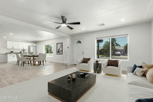 living area with recessed lighting, visible vents, baseboards, and ceiling fan