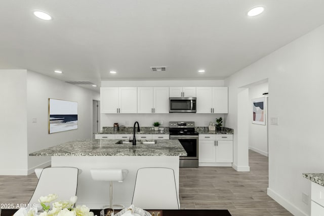 kitchen with a sink, stainless steel appliances, baseboards, visible vents, and recessed lighting