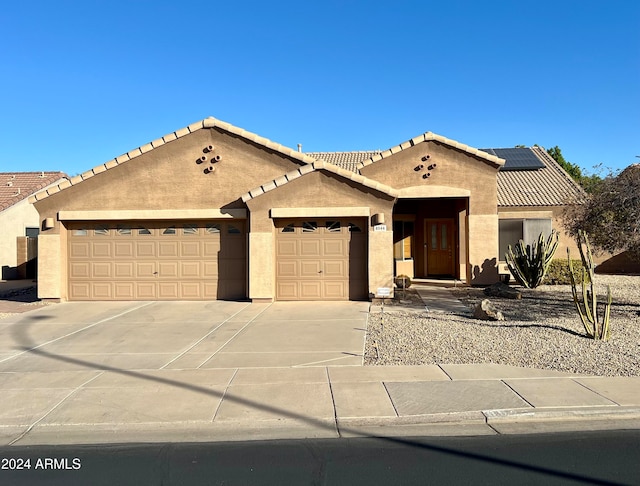 view of front of home featuring solar panels and a garage