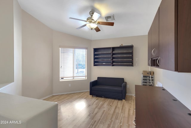 sitting room featuring light hardwood / wood-style floors, vaulted ceiling, and ceiling fan