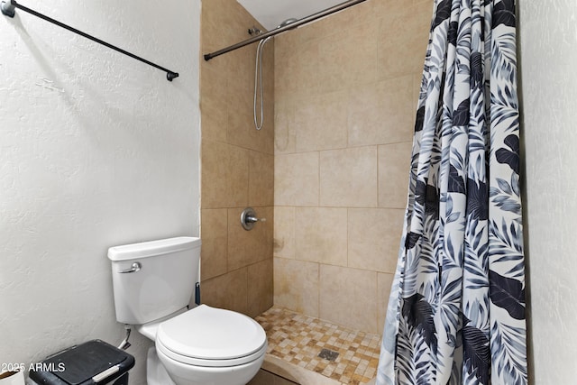 bathroom featuring a shower with curtain and toilet