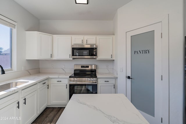 kitchen with light stone counters, stainless steel appliances, white cabinetry, dark hardwood / wood-style flooring, and sink