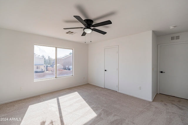 unfurnished bedroom featuring light colored carpet, ceiling fan, and a closet