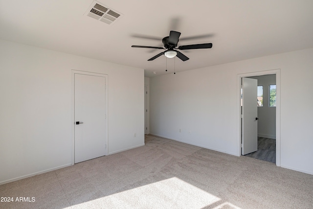 unfurnished bedroom featuring light colored carpet, ceiling fan, and a closet