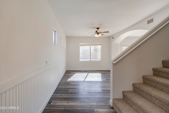 empty room with dark wood-type flooring and ceiling fan