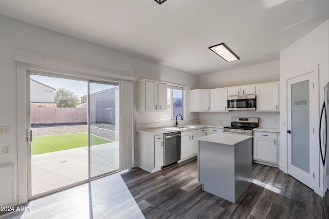 kitchen featuring a wealth of natural light, white cabinetry, appliances with stainless steel finishes, and a center island