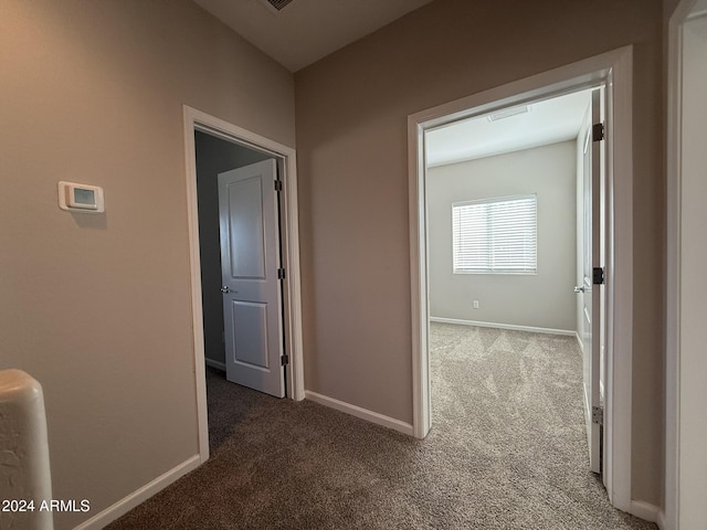 hall with dark colored carpet