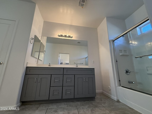 bathroom featuring tile patterned flooring, vanity, and combined bath / shower with glass door