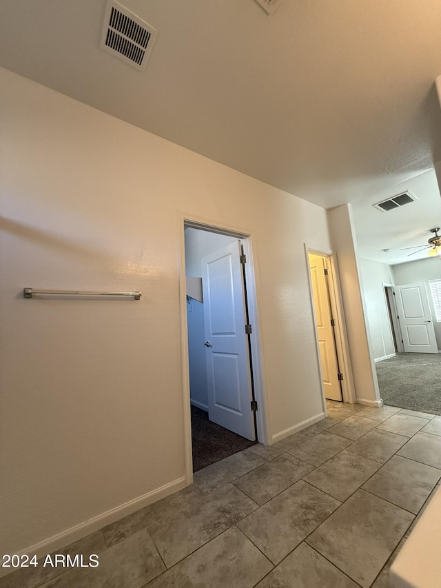 hall with tile patterned floors