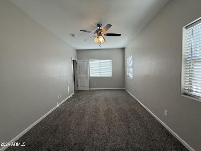 unfurnished bedroom featuring dark colored carpet and ceiling fan