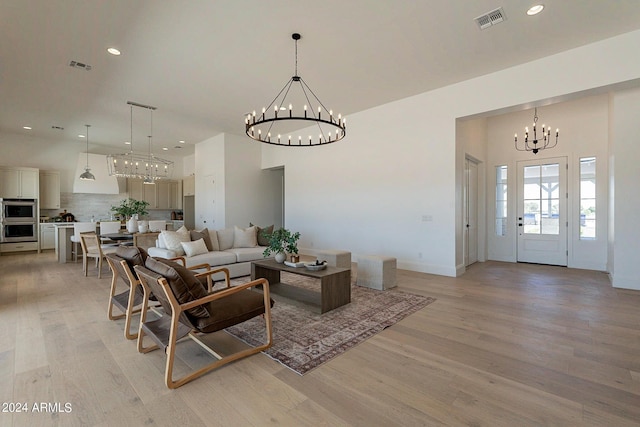 living room with an inviting chandelier and light hardwood / wood-style flooring